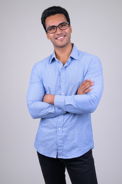 Portrait of young handsome Indian businessman on white