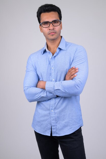 Portrait of young handsome Indian businessman on white