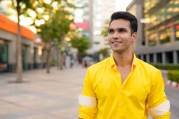 Photo portrait of young handsome indian man in the city streets outdoors