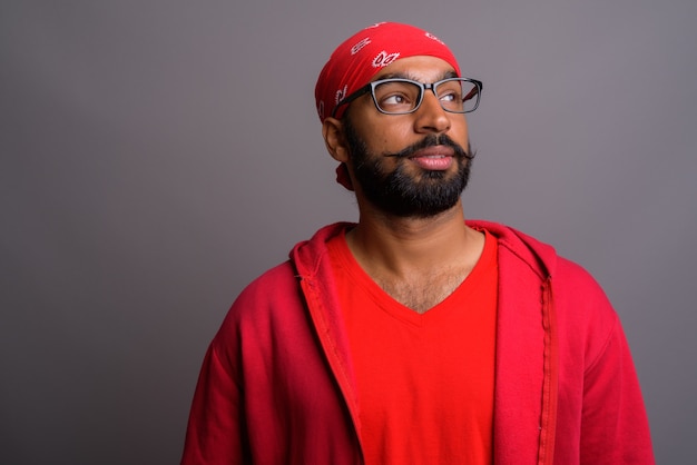 Portrait of young handsome Indian man thinking