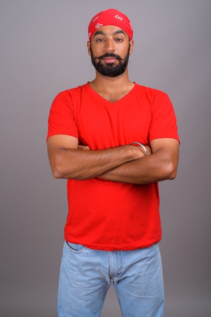 Portrait of young handsome Indian man wearing red shirt