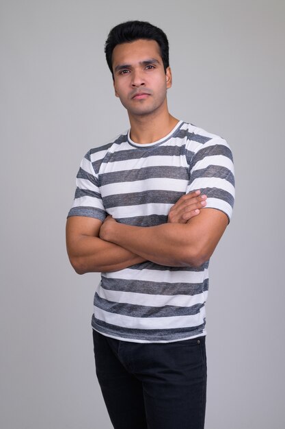 Portrait of young handsome Indian man on white