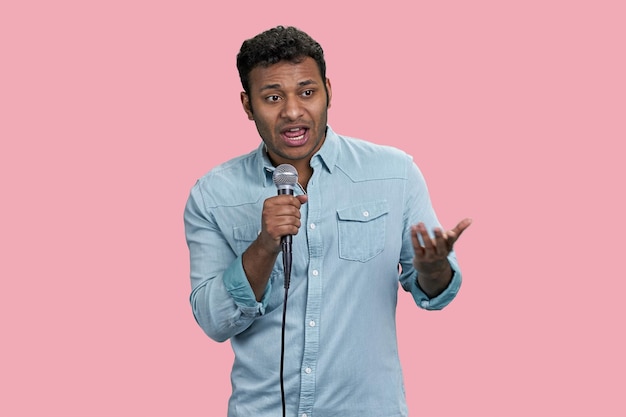 Portrait of a young handsome indian man with microphone