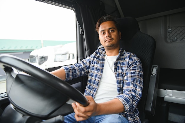 Portrait of a young handsome Indian truck driver The concept of logistics and freight transportation