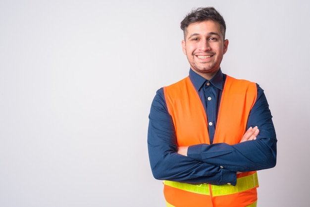 Portrait of young handsome Iranian man construction worker on white