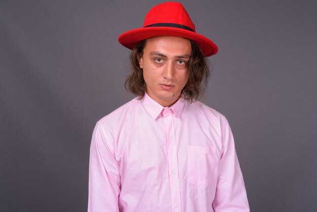 Portrait of young handsome man against gray wall