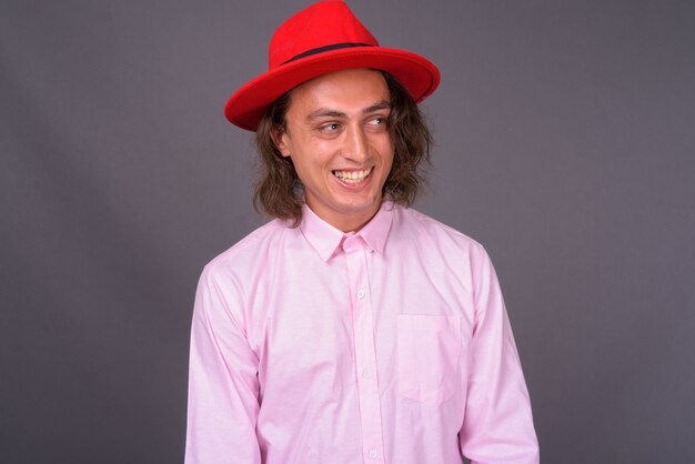 Portrait of young handsome man against gray wall