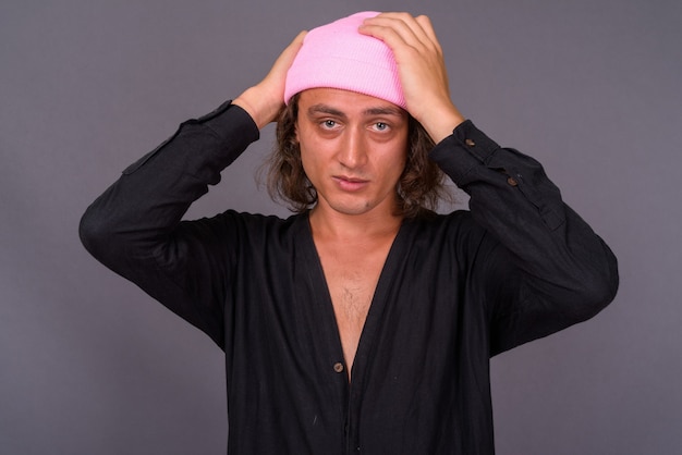 Photo portrait of young handsome man against gray wall