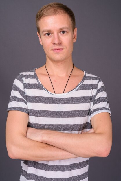 Portrait of young handsome man against gray wall