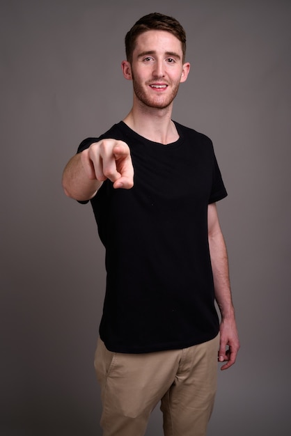 Portrait of young handsome man against gray