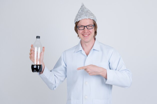 Photo portrait of young handsome man doctor wearing tin foil hat as conspiracy theory concept on white