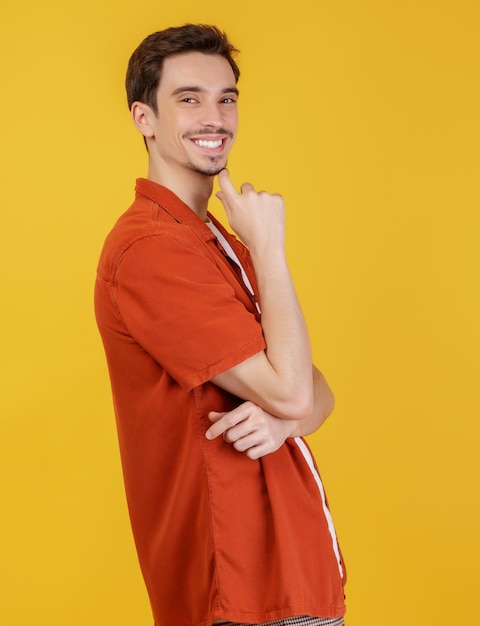 Portrait of young handsome man looking confident at the camera with smile with crossed arms and hand raised on chin over isolated background