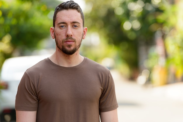 Photo portrait of young handsome man outdoors