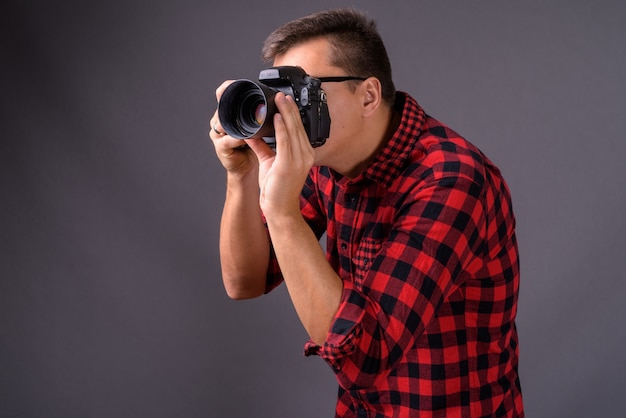 Portrait of young handsome man photographer holding camera