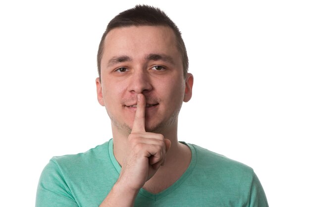 Portrait Of Young Handsome Man Quiet Gesture With Finger  Isolated On White Background