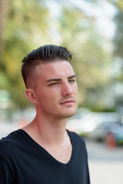 Portrait of young handsome man thinking outdoors