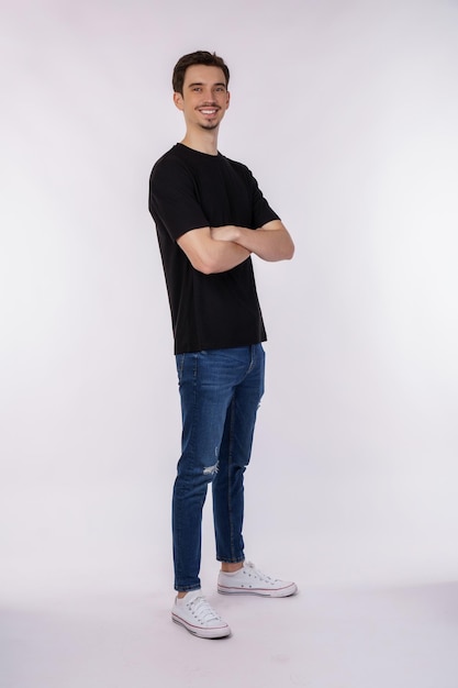 Portrait of young handsome man wearing black tshirt standing with crossed arms with isolated on studio white background