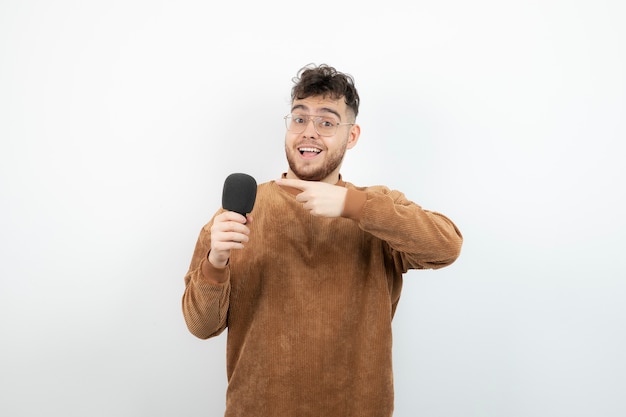 Portrait of young handsome man with microphone singing song. 