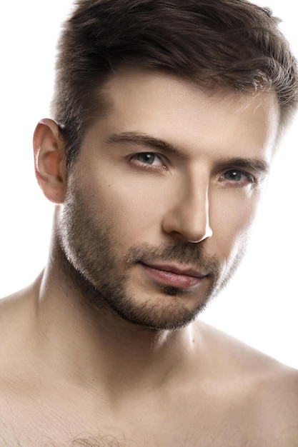 Portrait of young and handsome man with smooth skin posing on white background