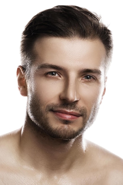 Portrait of young handsome man with wet face after shower on white background