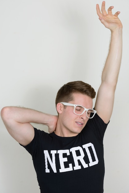 Photo portrait of young handsome nerd man against white wall