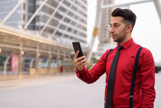 Portrait of young handsome Persian businessman exploring the city of Bangkok, Thailand