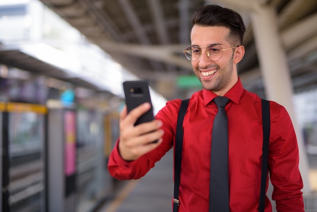 Portrait of young handsome Persian businessman exploring the city of Bangkok, Thailand