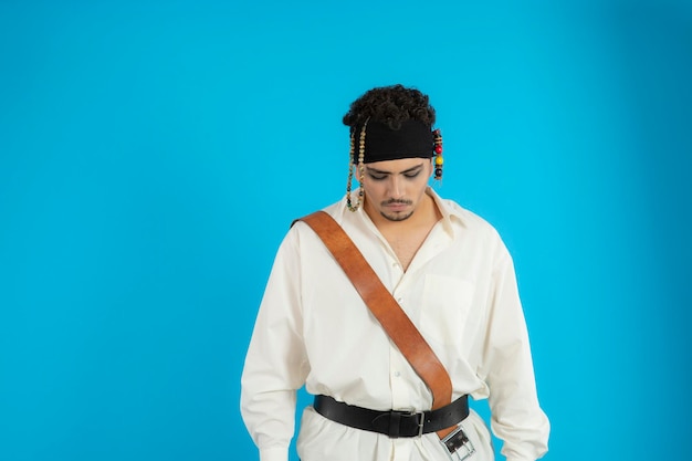 Portrait of young handsome prate stand on blue background and looking down. High quality photo