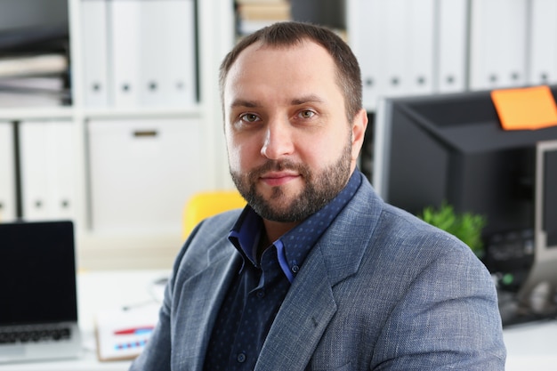 portrait of young handsome promising businessman in office