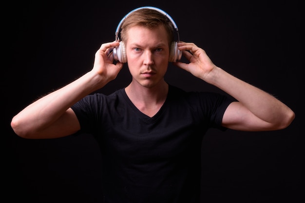 Photo portrait of young handsome scandinavian man on black