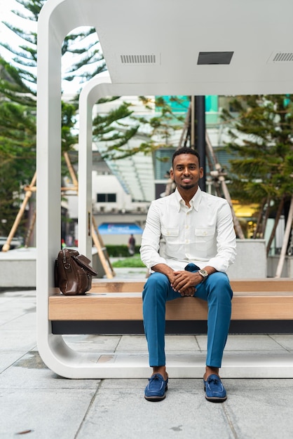 Portrait of young handsome stylish black man in city