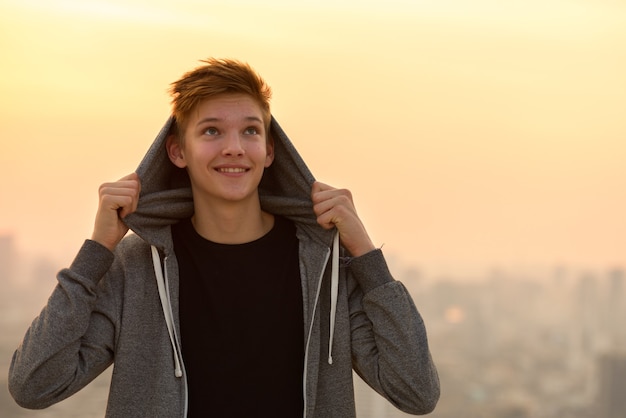 Ritratto di giovane adolescente bello contro la vista della città all'aperto