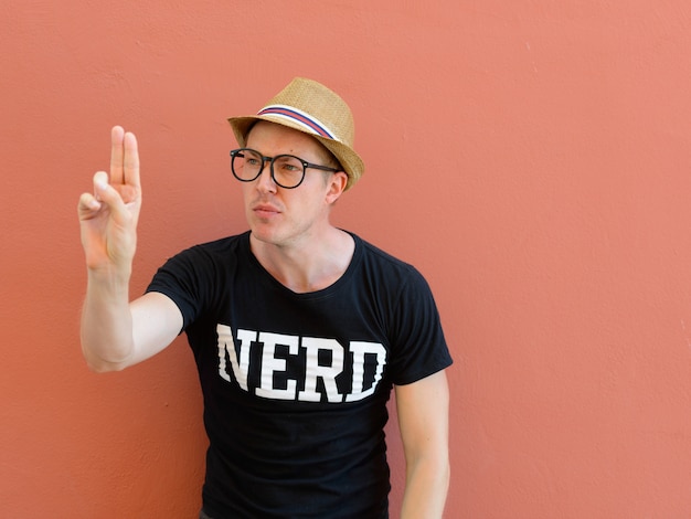 Photo portrait of young handsome tourist man as nerd against colored background outdoors