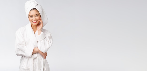 Portrait of a young happy asian lady in bathrobeIsolated in white background