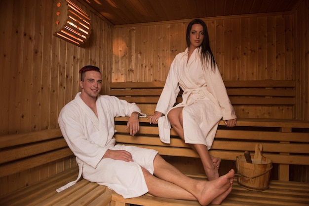 Portrait of a young happy beautiful couple enjoys relaxing in the sauna