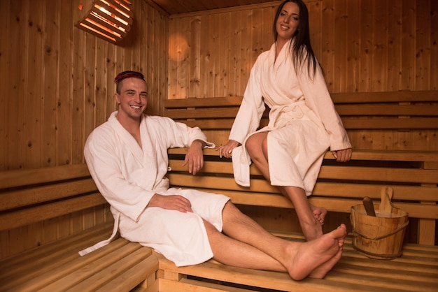 Portrait of a young happy beautiful couple enjoys relaxing in the sauna