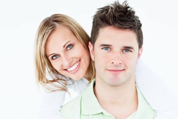 Portrait of a young happy couple standing against a white background