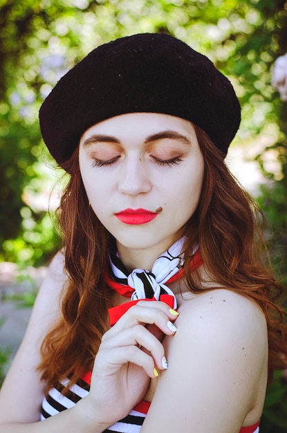 portrait. young, happy, elegant redhead woman, girl in hat, casual French clothes walking in city.