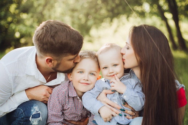 彼らの幼い息子にキス若い幸せな家族の肖像画