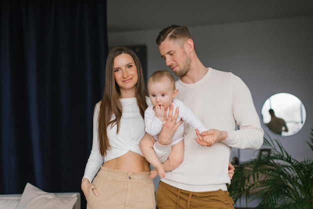 Portrait of a young happy family with a child in a cozy house