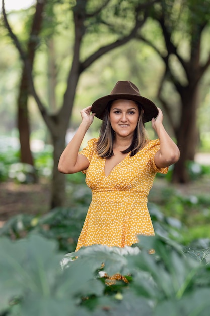 Portrait a young happy latin woman with yellow dress and hat