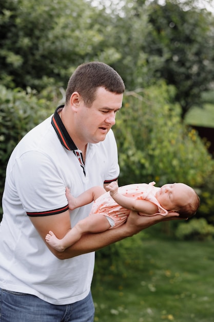 Portrait of young happy man holding his newborn cute baby