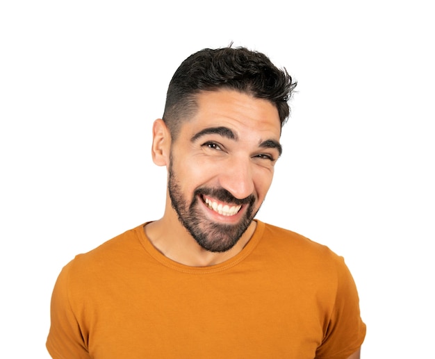 Portrait of young happy man smiling against white wall.