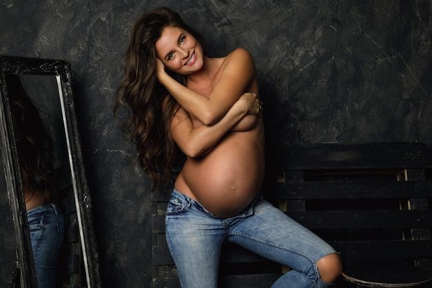 Portrait of young and happy pregnant woman with beautiful long hair