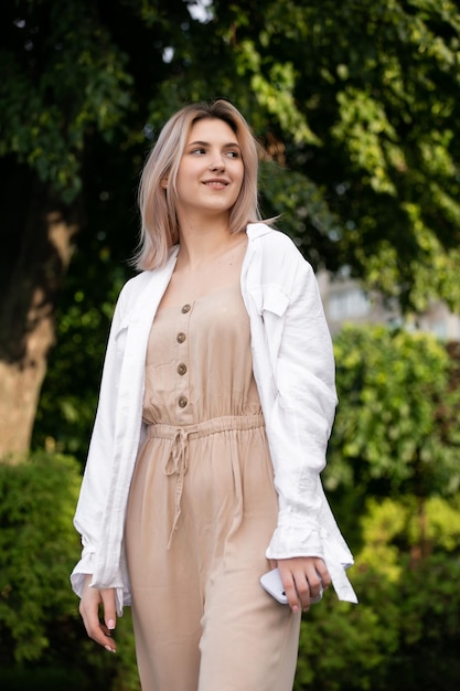 Portrait of a young happy and pretty blonde girl in green summer park