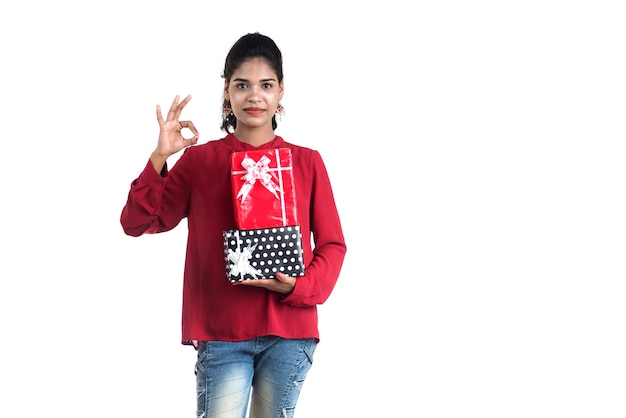 Portrait of young happy smiling Girl holding and posing with gift boxes on a white background.