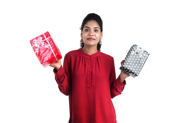 Portrait of young happy smiling Girl holding and posing with gift boxes on a white background.