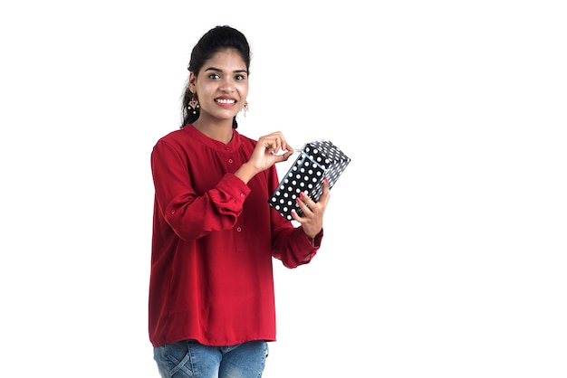 Portrait of young happy smiling Girl holding and posing with gift boxes on a white background.