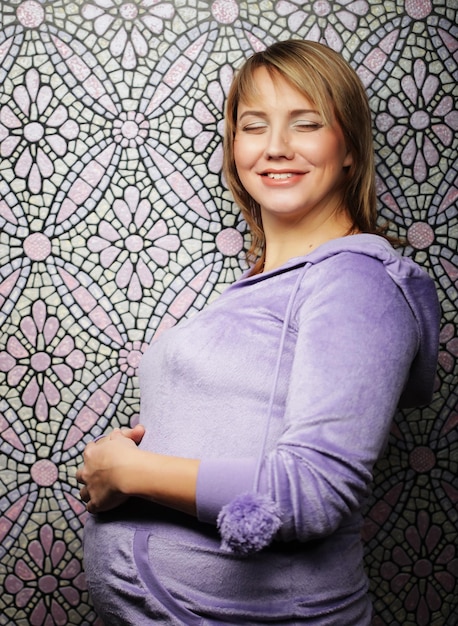 Портрет молодой счастливой улыбающейся беременной женщины
