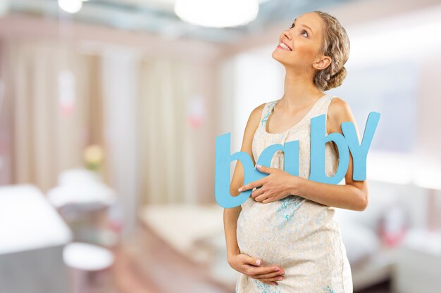 Портрет молодой счастливой улыбающейся беременной женщины